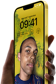 Main tenant un iPhone 14 Plus jaune où s’affiche un écran verrouillé personnalisé.